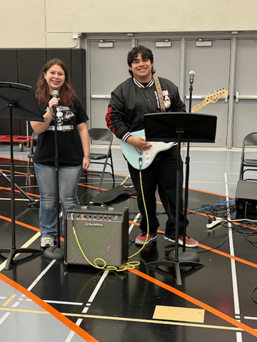 Student performers with mic and guitar at Art in the Burg